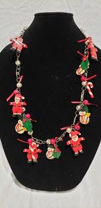 lot 771 image: Hand crafted holiday themed necklace with hand painted wooden figures of Santa, snowmen, holly leaves, candy canes etc. 28L