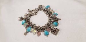lot 719 image: Disney (unmarked) Cinderella charm bracelet. Has charms Slipper on pillow, frog, key, castle, chair, heart with Her Royal Highness.