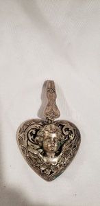 lot 721 image: Sterling or silver plated (unmarked) flying cherub (Cupid) with a Rodgers extra plate utensil clasp mount. Does not stick to magnet.