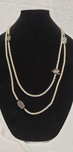 lot 737 image: Signed vintage T Foree (Peterson Hunsicker, Dallas TX designer) sterling and faux pearl necklace.  One spacer is a cupid. Marked Foree 925 in several spots. Opera length - 60L