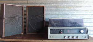 lot 14 image: Clarinets 92  AMFM 8 track music system model 13--1201D  coated wood grain has 2 speakers, cables need repair untested