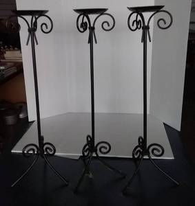 lot 68 image: 3 Tall Black Iron Candleholders, and 2 Iron Hanging Plate Racks. Candlestands are 26 Tall.