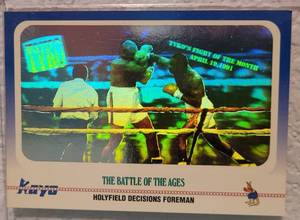 lot 64 image: 1991 KAYO CARDS #100 HOLOGRAPHIC THE BATTLE OF THE AGES HOLYFIELD DECISIONS FOREMAN BOXING CARD IN PROTECTIVE SLEEVE AS SHOWN.