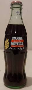 lot 130 image: 1997 EVANDER HOLYFIELD THE REAL DEAL ALWAYS A CHAMPION FULL COMMEMORATIVE COCA-COLA BOTTLE AS SHOWN. DATED NOV. 17, 1997.