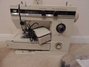 lot 23 image: Sewing lot-thimbles, needles, scissors, fabric 1 button case and a Wards stich selector sewing machine