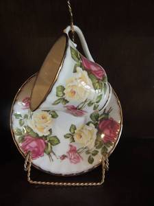 lot 112 image: Pink flower bone china tea cup and saucer on gold display stand