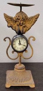 lot 183 image: CAST IRON CANDLE HOLDER WITH CLOCK IN STYLE, COLOR, AND CONDITION SHOWN. 4.5 W x 4.5 D x 7.5 H