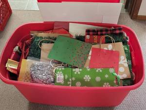 lot 186 image: LARGE PLASTIC STORAGE BIN FULL OF CHRISTMAS GIFT BAGS, WRAPPING PAPER AND MORE AS SHOWN.