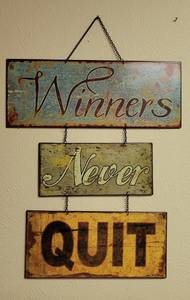 lot 191 image: WINNERS NEVER QUIT METAL WALL HANGING IN STYLE, COLOR, AND CONDITION SHOWN. 15.5 W x 23 H