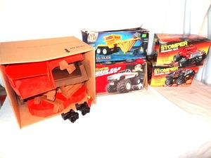 lot 61 image: Lot of 3 vintage Stomper 4x4 trucks - unused, in boxes - includes pull sled and obstacle track