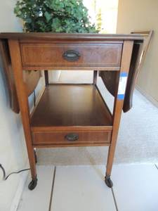 lot 23 image: Antique TV cart on wheels. 2 drawers both sides fold up 29 tall sides up 40 sides down 18
