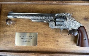 lot 11 image: Wyatt Earp .44 revolver made by the Franklin Mint. A 6 shot revolver that is engraved.Matching serial number to original gun  SN# 20029   Comes with hardwood display & plaque,  GUN IS 13 12 IN length  IThis is a non-shooting replica.