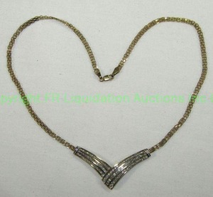 lot 423 image: 10K Gold 16 Necklace with attached Overlapping V Pendant. Clasp and Pendant Marked 10K 1TW One Carat total weight approx. Round and baguette diamonds. Diamonds tested.