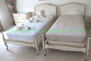 lot 596 image: French provincial style single beds on castors, matched pair
