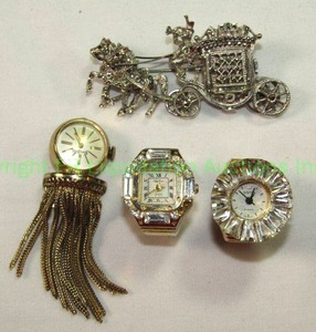 lot 567 image: Watch group - Neiman Marcus Brooch Watch, 2 adjustable ring watches and a figural carriage marcasite watch brooch. (4 ct)