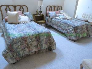 lot 687 image: Single beds with fruit wood white washed interlocking ring design, shell header centerpiece, includes bedding items (Mattress free for the taking). Pair Mattresses FREE to high bidder