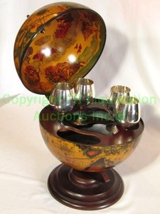 lot 370 image: Horchow Italian figural world globe with hinged top. Decorated interior and fitted tray with 4 silver plate goblets