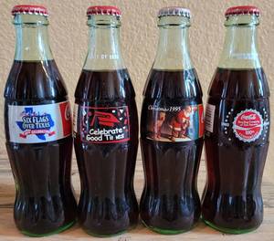 lot 242 image: LOT OF 4 COCA-COLA UNOPENED COMMEMORATIVE COLLECTIBLE BOTTLES AS SHOWN.