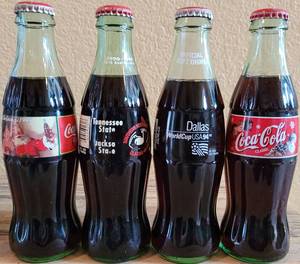 lot 243 image: LOT OF 4 COCA-COLA UNOPENED COMMEMORATIVE COLLECTIBLE BOTTLES AS SHOWN.