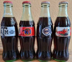 lot 244 image: LOT OF 4 COCA-COLA UNOPENED COMMEMORATIVE COLLECTIBLE BOTTLES AS SHOWN.