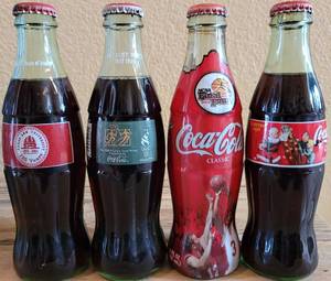 lot 246 image: LOT OF 4 COCA-COLA UNOPENED COMMEMORATIVE COLLECTIBLE BOTTLES AS SHOWN.