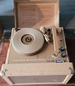 lot 112 image: VINTAGE PORTABLE NEWCOMB SOLID STATE SUITCASE RECORD PLAYER FOR STEREOMONO RECORDS AS SHOWN. NORTWEST LIBRARY SYSTEM - PANAMA CITY, FLORIDA Approx. 14.25 W x 8.25 D x 14.25 H.
