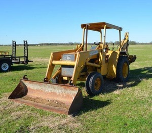 lot 1 image: John Deere Tractor 310A, bucket and backhoe. Forklift Fork Included. (Needs new seat) runs and starts battery currently disconnected Checkout the videos of it running on Facebook D&S Specialties link below