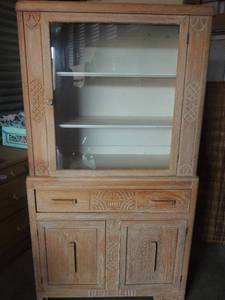 lot 10 image: Depression era Hoosier cabinet with display shelves and glass front upper door. White washed finish. Original 1930s applied decoration and streamlined handles. 64x35x15