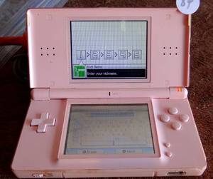 lot 84 image: Nintendo DS Lite Coral Pink Handheld System  - W Hello Kitty, Big City Dreams Game - WORKING