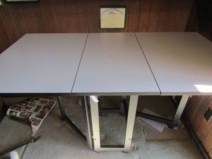 lot 25 image: Seamstress or fabric cutting crafting table on wheels.With  drop sides 36h 60w 30d  white top metal base on wheels
