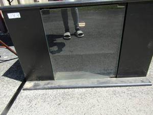 lot 143 image: Black TV cabinet with shelving on both sides glass front door 1 shelf inside