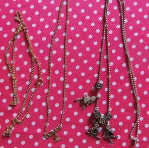 lot 195 image: 1 birthstone baby necklace  purple, clear, & green. 1 Gemini necklace 1 gold tone chain