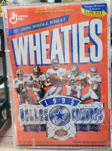 lot 242 image: 1995 COLLECTIBLE DALLAS COWBOYS SUPER BOWL CHAMPS WHEATIES CEREAL BOX IN ACRYLIC PROTECTOR AS SHOWN. BOX APPEARS TO BE FULL AND UNOPENED.