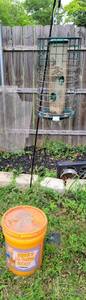 lot 510 image: BIRD FEEDER WITH STAND PLUS BUCKET OF BIRD FEED AS SHOWN.
