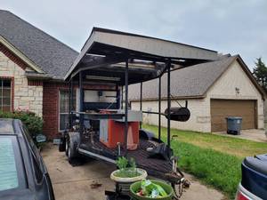lot 1 image: DOUBLE-AXLE HEAVY DUTY ROOF TRAILER WITH CUSTOM-MADE SMOKER, TWO BUILT-IN PROPANE BURNERS WITH 2 TANKS (NOT PICTURED), GRILL, ISLANDPREP STATION WITH STORAGE, SINKFAUCET, WATER RESERVOIR TANK AND MORE. TRAILER HAS POWER OUTLETS AND LIGHTS AS SHOWN.