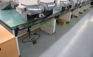 lot 580 image: Laminate top double sided work station. 27ft long (Contents not included)