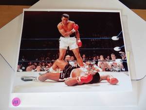 lot 113 image: GOAT MUHAMMAD ALI 8 X 10 ICONIC PHOTO STANDING OVER SONNY LISTON