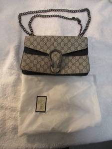 lot 104 image: GUCCI-  Dionysus small GG shoulder bag, With flap with a tiger head spur magnetic fastening  and sliding chain strap, And Dust Bag