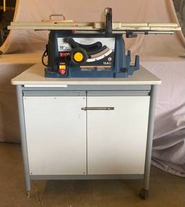 lot 15 image: Ryobi RT520 120V 60 Hz 15A 5000 rmin 10 Table Saw Attached to Cabinet with wheels