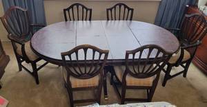 lot 187 image: VINTAGE OBLONG DINING TABLE WITH 6 CHAIRS IN STYLE, COLOR, AND CONDITION SHOWN. 2 CAPTAIN CHAIRS AND 4 SIDE CHAIRS. TABLE COMES WITH A CUSTOM PAD COVER AS SHOWN. CHECK IT OUT (YOUR BID X 7) Approx. 73 x 44 x 28.5.