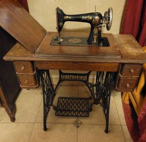 lot 2 image: Antique Singer treadle sewing machine with cabinet including sewing notions in drawers as shown. Circa 1910-1920.