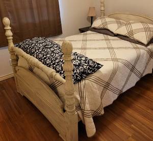 lot 56 image: Wooden full size bed with bedding as shown.