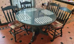 lot 69 image: Round wooden dining table with glass top and 4 chairs in style, color, and condition shown. (Your bid x 5)