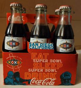 lot 86 image: Six pack of 1998 Super Bowl XXXII commemorative Coca-Cola bottles with carton as shown.