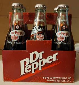 lot 87 image: Six pack of Dublin Dr. Pepper celebrating 111 years commemorative bottles with carton as shown.