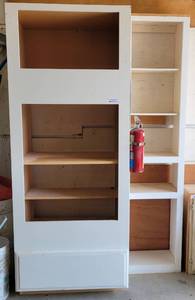 lot 26 image: WOODEN CABINET  SHELF UNIT AS SHOWN. MEASURES APPROX. 53 W x 26 D x 83 H. UNIT IS BOLTED TO THE WALL. BUYER MUST BRING TOOLS FOR PROPER REMOVAL FIRE EXTINGUISHER AND SIGN NOT INCLUDED