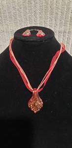 lot 555 image: Signed,boxed Lia Sophia (1986-2014) Share The Love Of Jewelry Dichroic red and gold fused glass pendant on 16L cloth and ribbin necklace w matching earrings.