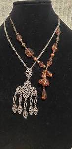 lot 564 image: (2) metal dangle necklaces Both 18L  One has antique patinated chain.