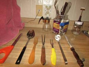 lot 119 image: Glass syrup container, hand mixer, nut crackers and large spoons and knives