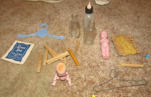 lot 257 image: DOLL Lot- flower vase, diaper pins, dolls, jugs, bottles